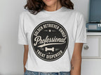 White t-shirt with a circular black graphic that says "Professional Golden Retriever Owner Treat Dispenser".