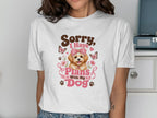 White t-shirt with "Sorry, I Have Plans With My Dog" and a cartoon dog.