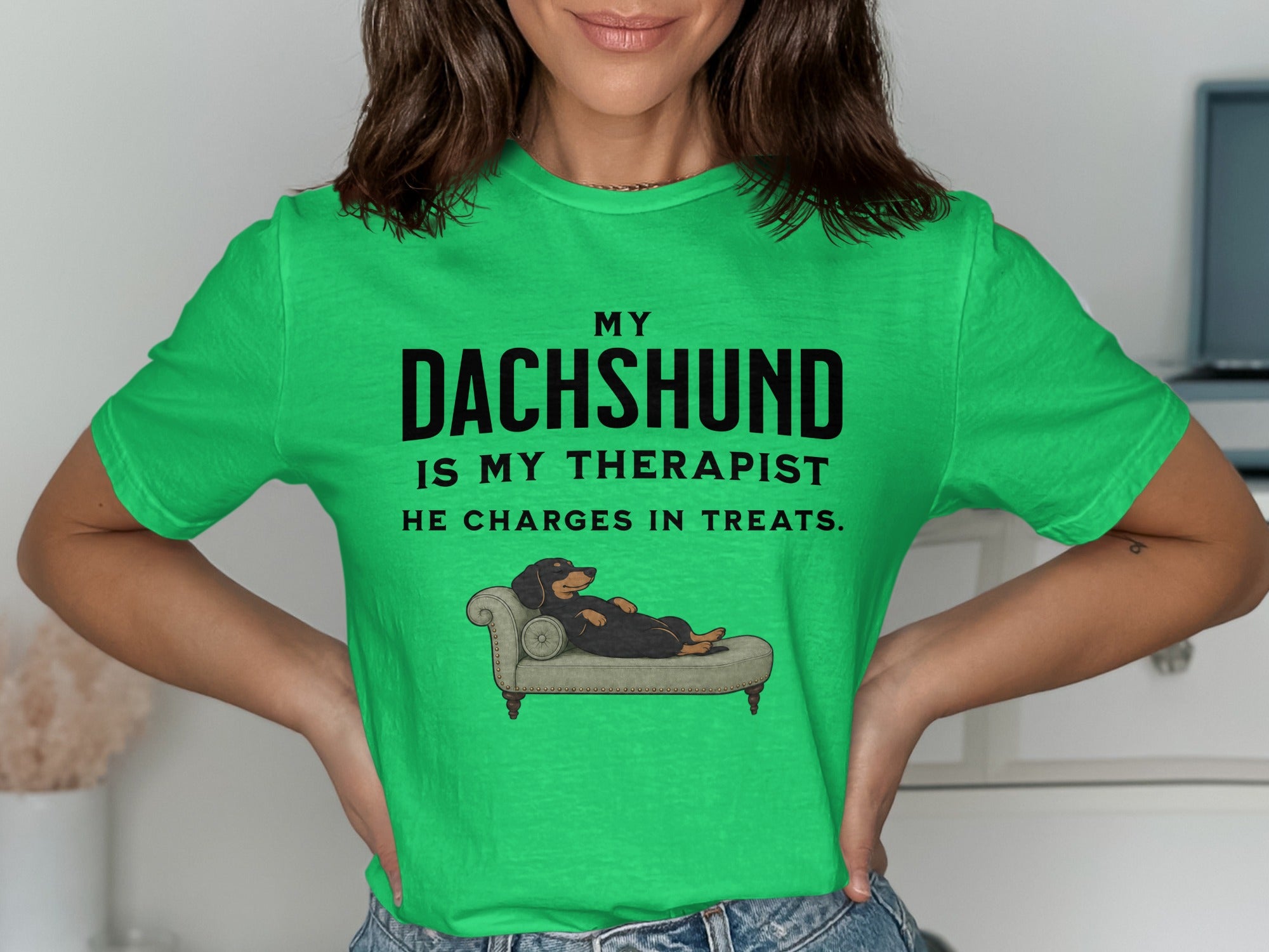Green t-shirt with text "MY DACHSHUND IS MY THERAPIST HE CHARGES IN TREATS" and dog on chaise lounge.