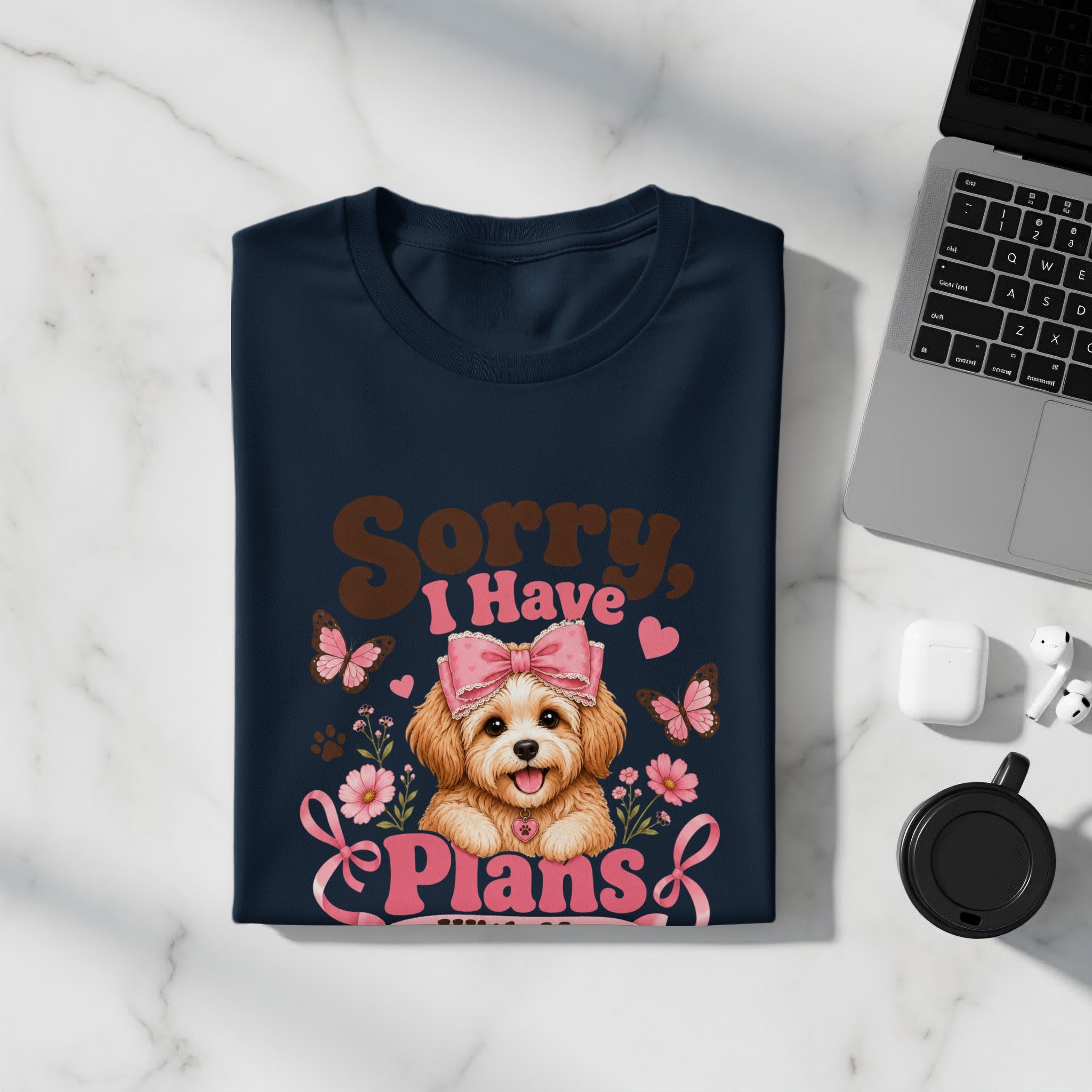 Navy t-shirt with a graphic of a dog, pink bow, butterflies, flowers, and text "Sorry, I Have Plans".