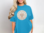 Dachshund Garden Club circular logo with dog and floral accents on blue t-shirt.