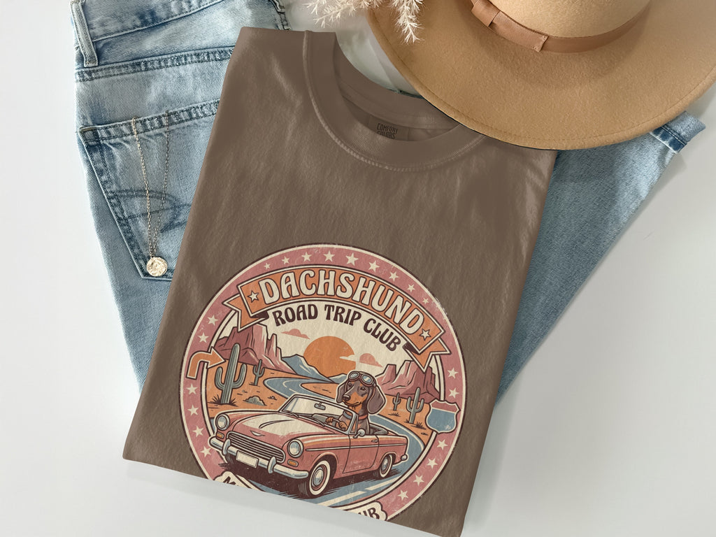 Brown t-shirt featuring a dachshund in a convertible on a road trip.