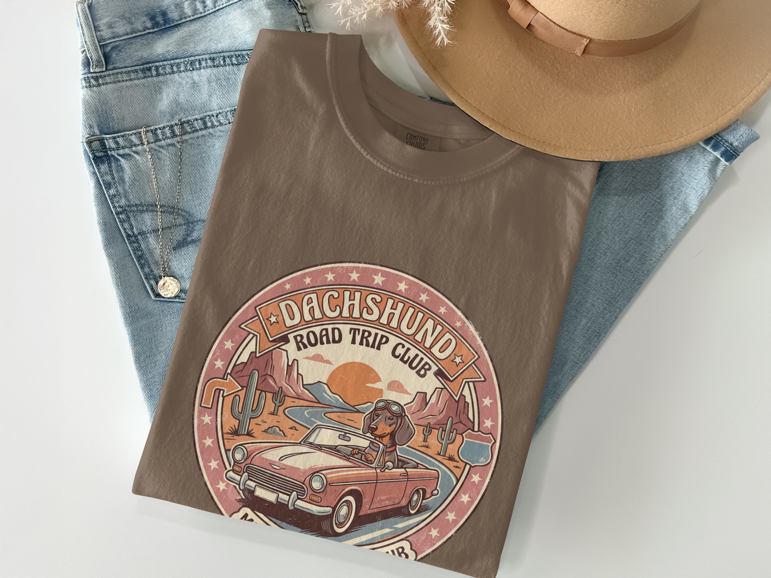 Brown t-shirt featuring a dachshund in a convertible on a road trip.