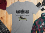 Grey t-shirt with text "My Dachshund is my therapist he charges in treats."