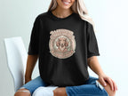 Dachshund Garden Club logo with a dog, flowers, and gardening tools on a black t-shirt.