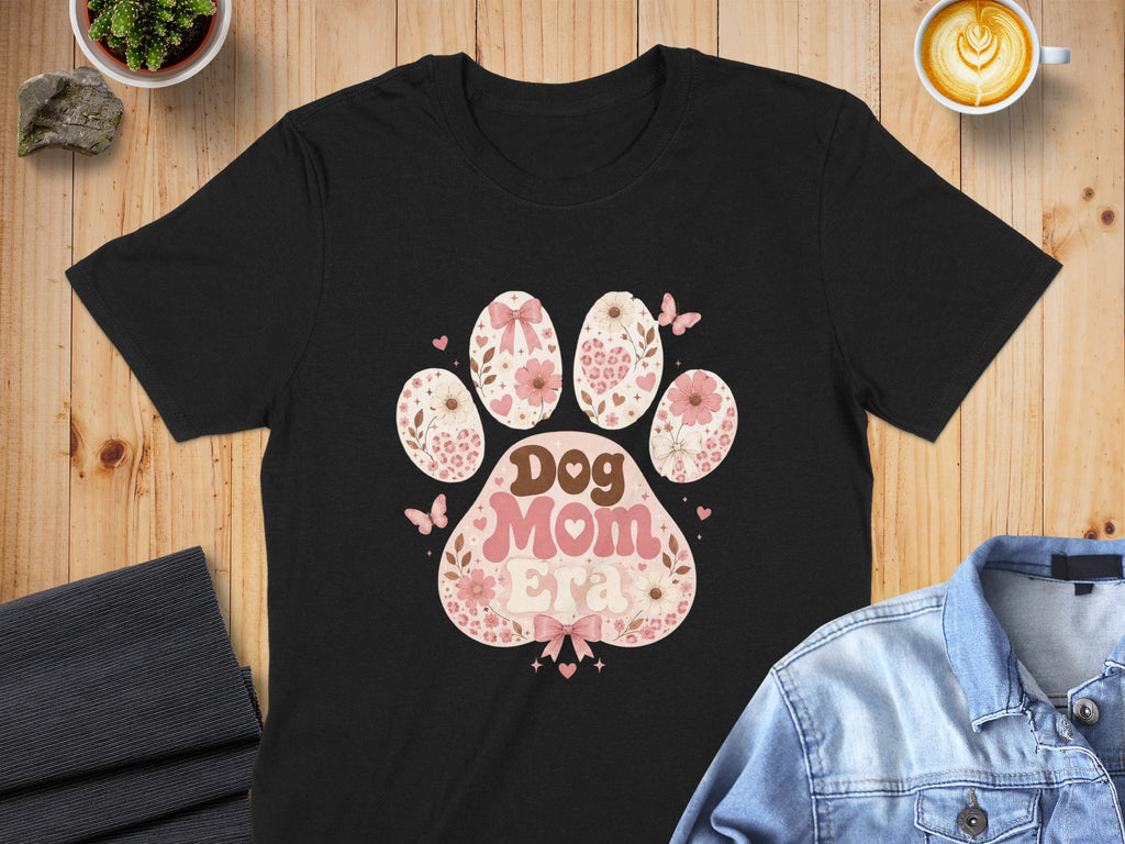 Black t-shirt with "Dog Mom Era" text inside a floral paw print.